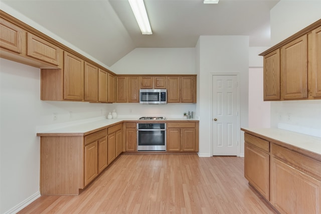 kitchen with high vaulted ceiling, appliances with stainless steel finishes, and light wood-type flooring