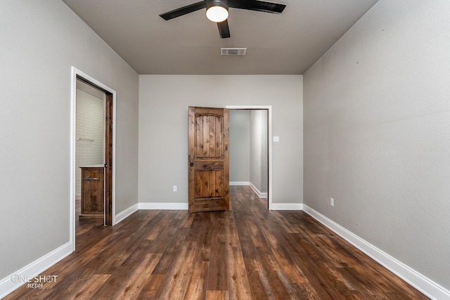 unfurnished bedroom featuring ceiling fan and dark hardwood / wood-style flooring