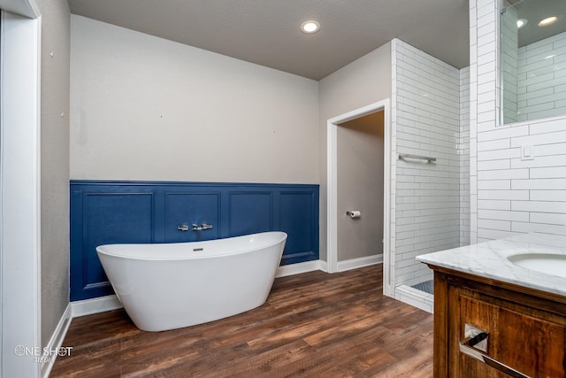 bathroom featuring separate shower and tub, vanity, and hardwood / wood-style flooring