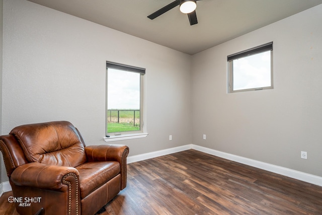 living area featuring ceiling fan and dark hardwood / wood-style flooring