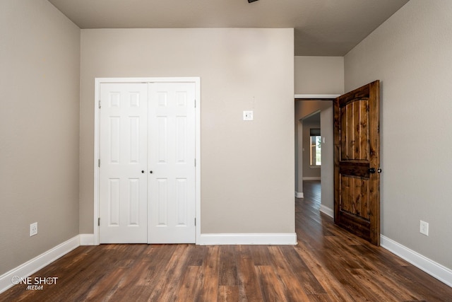 unfurnished bedroom featuring dark hardwood / wood-style floors and a closet