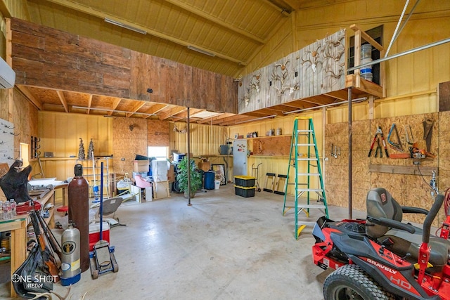 garage featuring a workshop area and wooden walls