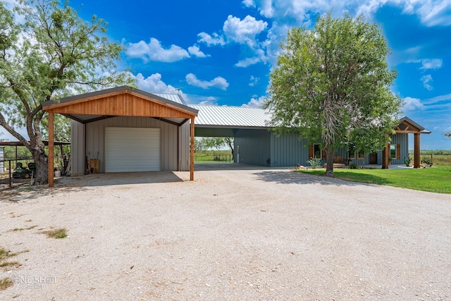 view of front of home with a carport, a garage, and an outdoor structure