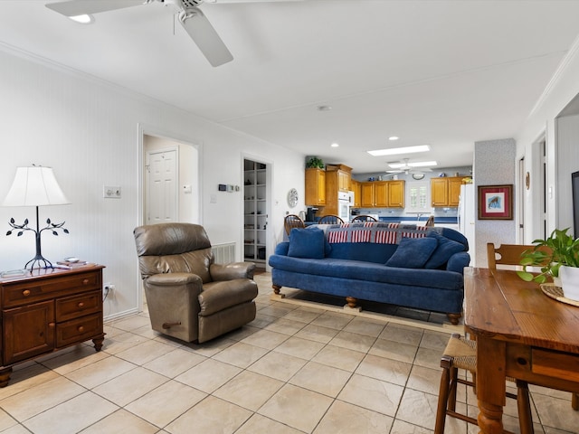 living room featuring crown molding, light tile patterned floors, and ceiling fan