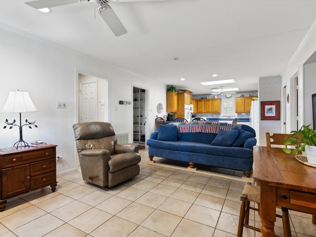 tiled living room with ceiling fan and ornamental molding