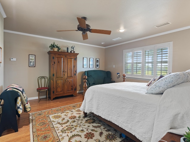 bedroom with light hardwood / wood-style flooring, ornamental molding, and ceiling fan