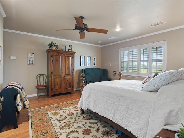 bedroom with ceiling fan, ornamental molding, and light hardwood / wood-style flooring