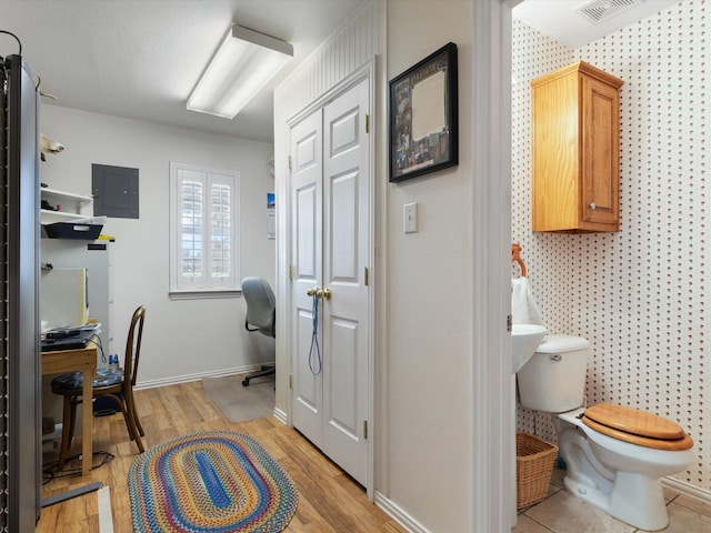 office featuring light hardwood / wood-style floors and electric panel