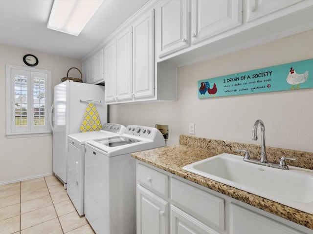 clothes washing area with cabinets, sink, washer and dryer, and light tile patterned floors