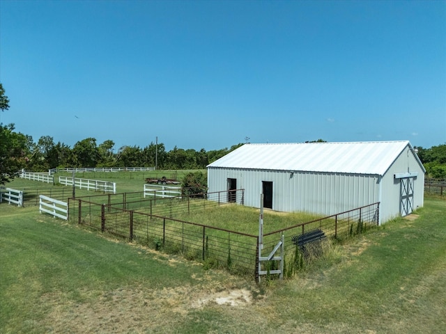 view of outbuilding with a rural view and a yard