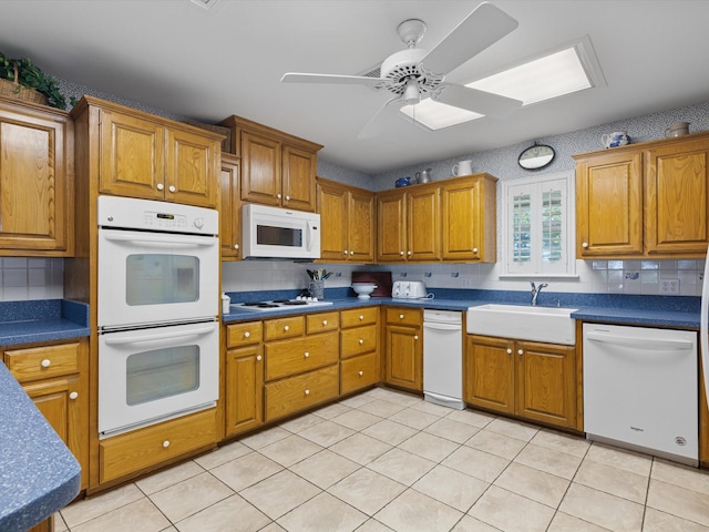 kitchen featuring ceiling fan, white appliances, sink, and decorative backsplash