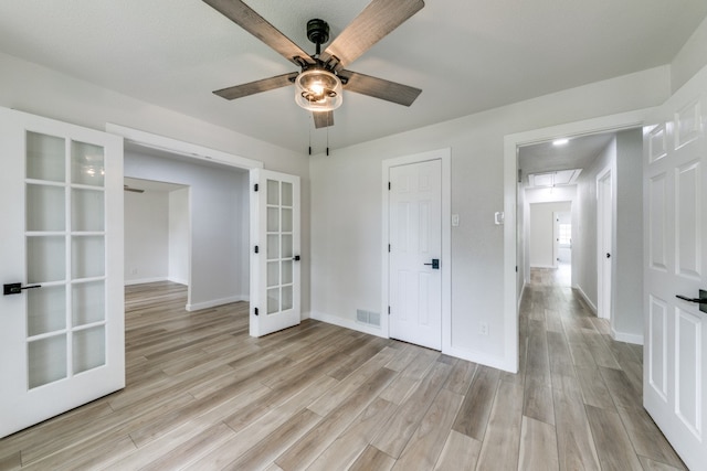 unfurnished room featuring light hardwood / wood-style flooring, french doors, and ceiling fan