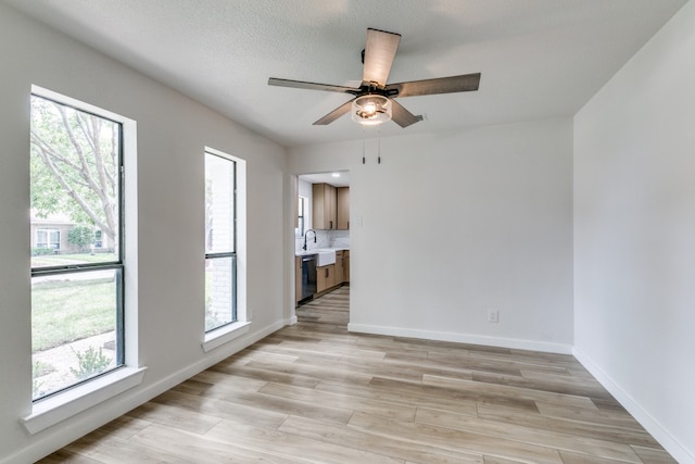 empty room featuring light wood-type flooring, ceiling fan, and a wealth of natural light