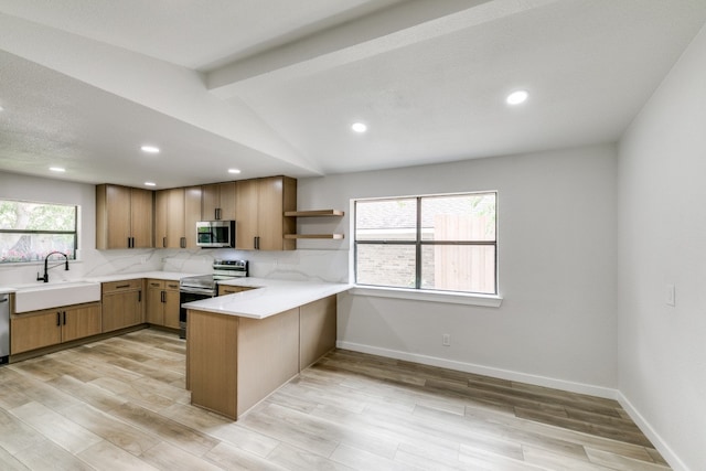 kitchen featuring light wood-type flooring, kitchen peninsula, backsplash, stainless steel appliances, and sink