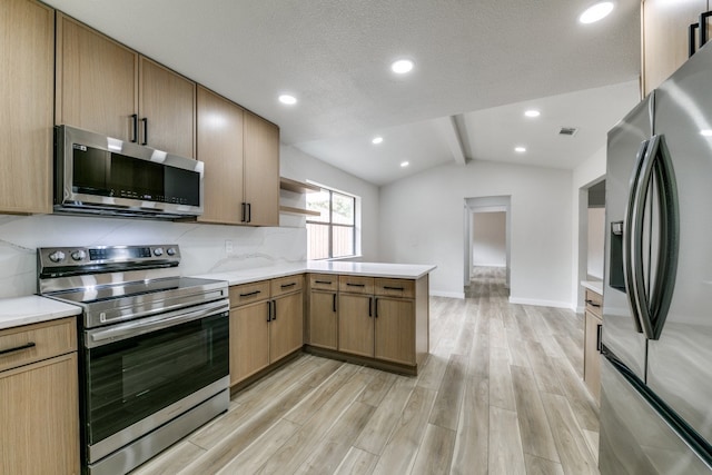 kitchen featuring a textured ceiling, kitchen peninsula, light hardwood / wood-style floors, appliances with stainless steel finishes, and lofted ceiling with beams