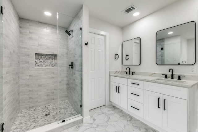 bathroom with a shower with shower door, tile patterned floors, and dual bowl vanity