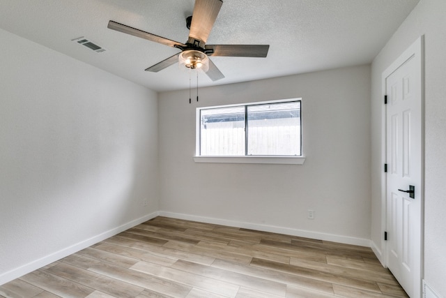 spare room featuring light hardwood / wood-style floors, a textured ceiling, and ceiling fan