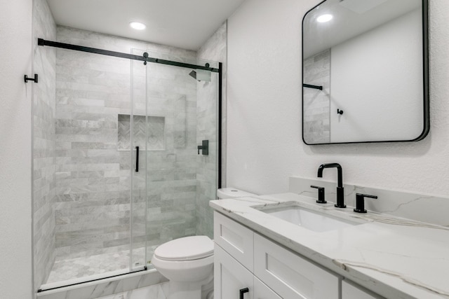 bathroom featuring tile patterned floors, a shower with door, toilet, and vanity