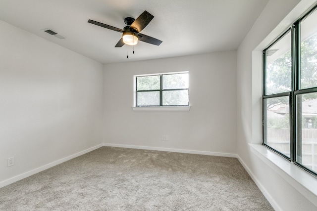 carpeted spare room with a healthy amount of sunlight and ceiling fan