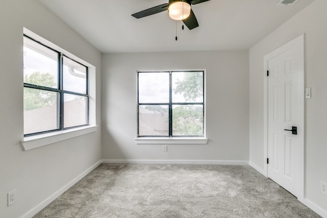 spare room featuring light carpet and ceiling fan