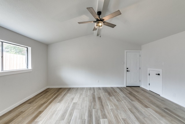 empty room featuring light hardwood / wood-style floors, lofted ceiling, and ceiling fan