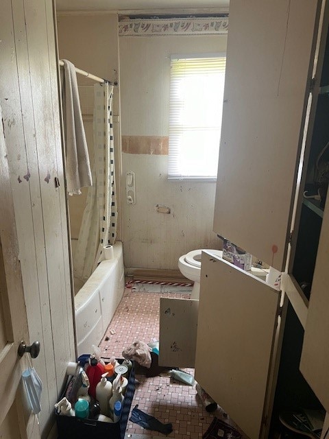 bathroom featuring toilet, a wealth of natural light, and shower / bath combo