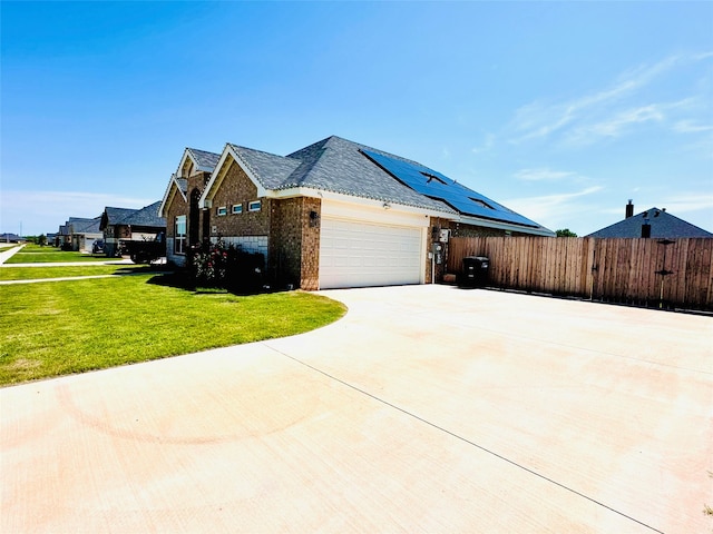 view of home's exterior with a garage, a yard, and solar panels