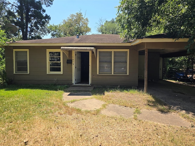 view of front facade featuring a front yard and a carport