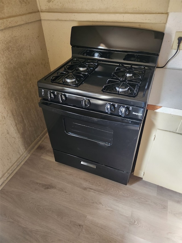 room details featuring black gas stove and light hardwood / wood-style floors