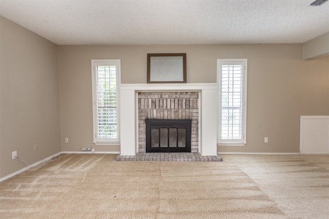 unfurnished living room with a textured ceiling, carpet floors, and a fireplace