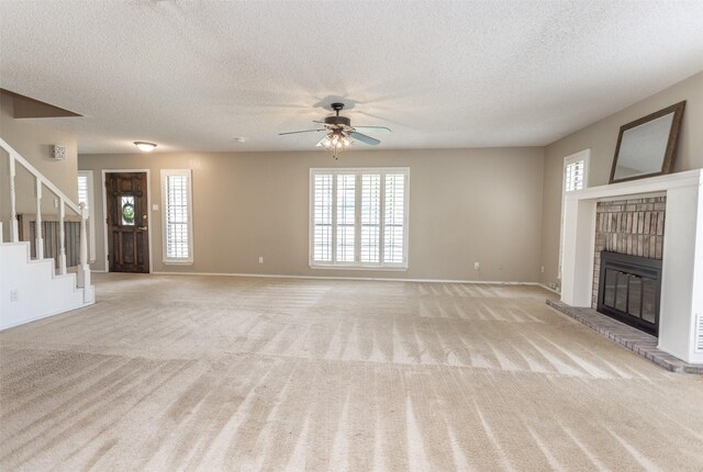 unfurnished living room with light carpet, a textured ceiling, a brick fireplace, and ceiling fan