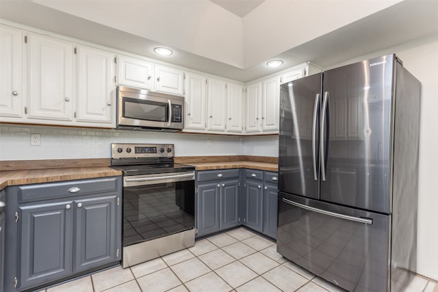 kitchen with white cabinetry, light tile patterned floors, gray cabinets, appliances with stainless steel finishes, and decorative backsplash