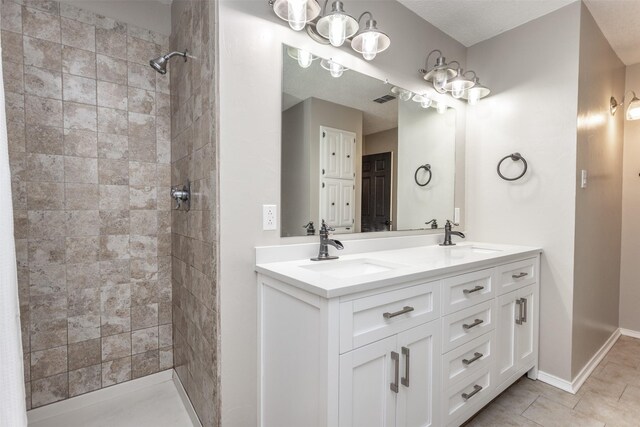 bathroom featuring tile patterned flooring, double sink vanity, and a notable chandelier