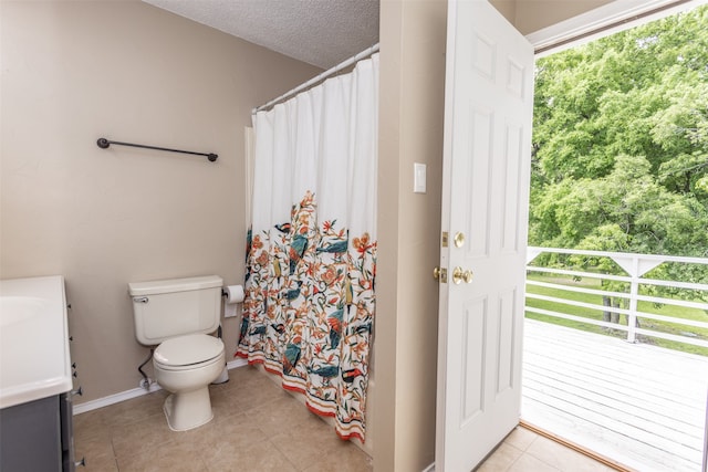 bathroom featuring tile patterned flooring, toilet, vanity, and a textured ceiling