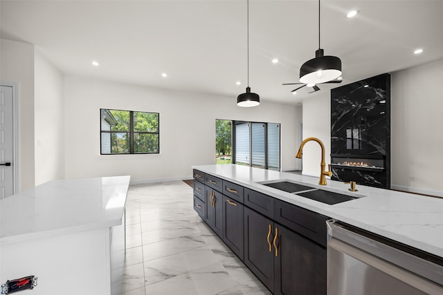 kitchen with sink, light stone counters, hanging light fixtures, light tile patterned floors, and dishwasher