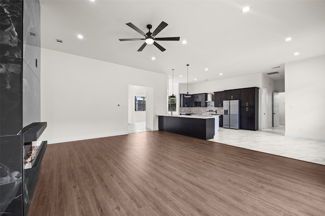 unfurnished living room with ceiling fan and light wood-type flooring