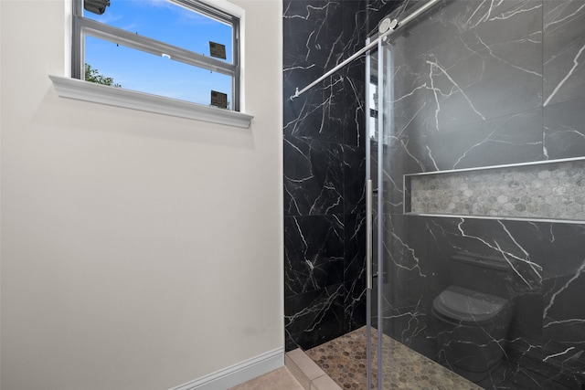 bathroom featuring toilet and a tile shower