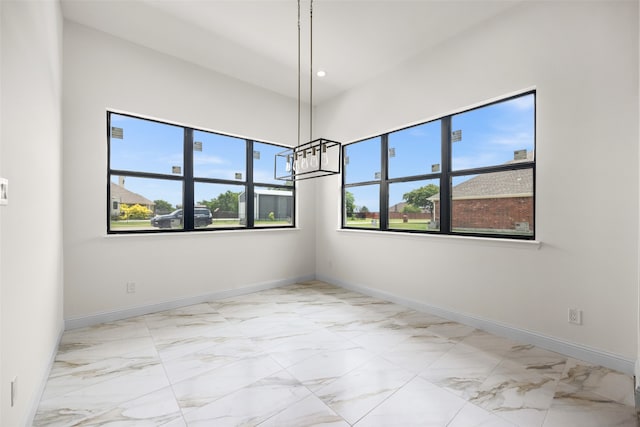 tiled spare room with an inviting chandelier and plenty of natural light