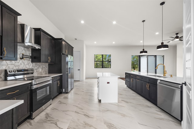 kitchen with tasteful backsplash, wall chimney range hood, ceiling fan, stainless steel appliances, and sink