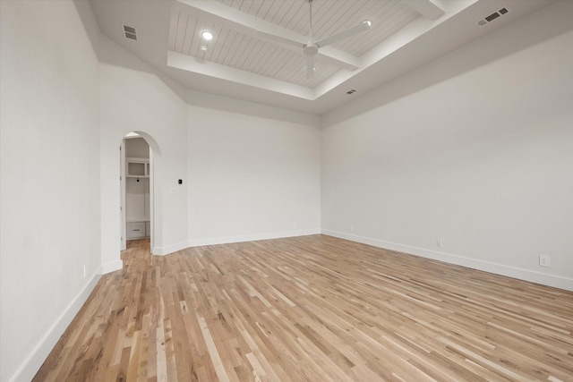 empty room with beamed ceiling, ceiling fan, wooden ceiling, and light hardwood / wood-style floors