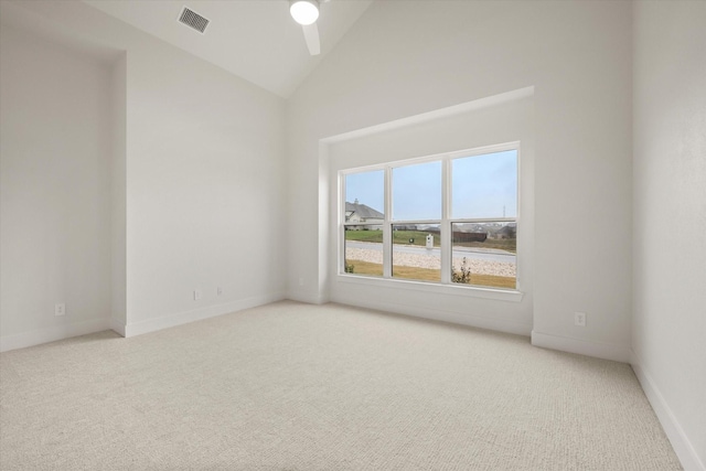 carpeted spare room featuring high vaulted ceiling