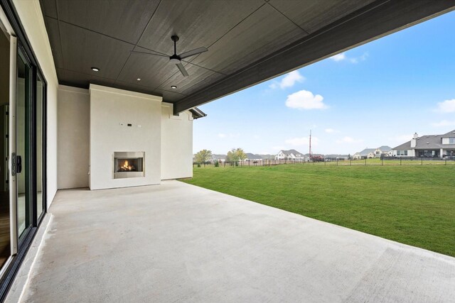 view of patio / terrace featuring ceiling fan and a fireplace