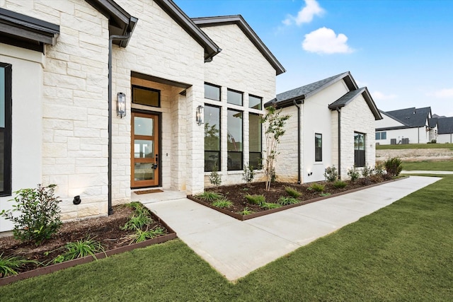 view of exterior entry with a lawn