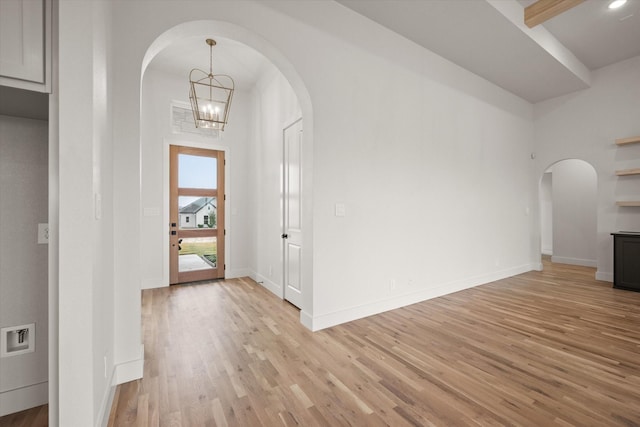 foyer entrance with a notable chandelier and light hardwood / wood-style flooring