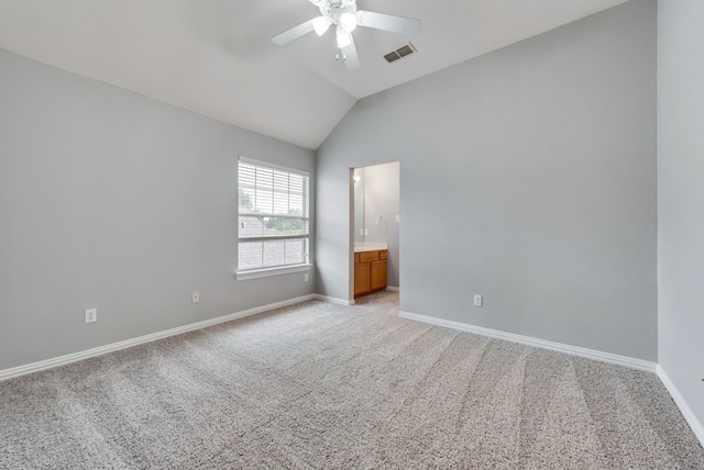 spare room featuring ceiling fan, light colored carpet, and vaulted ceiling