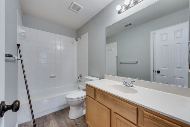 full bathroom featuring hardwood / wood-style floors, toilet, vanity, and tiled shower / bath