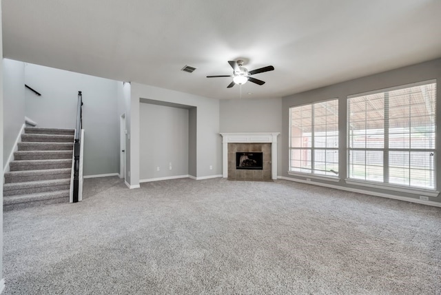 unfurnished living room featuring ceiling fan, carpet flooring, and a fireplace