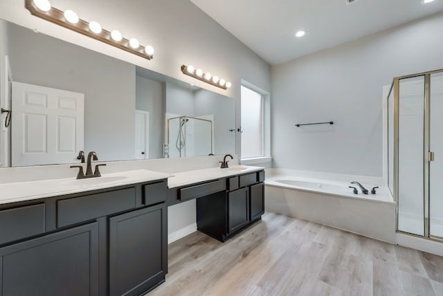 bathroom featuring wood-type flooring, vanity, and separate shower and tub