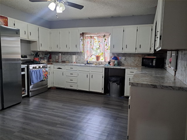 kitchen with dark hardwood / wood-style flooring, sink, white cabinets, and appliances with stainless steel finishes