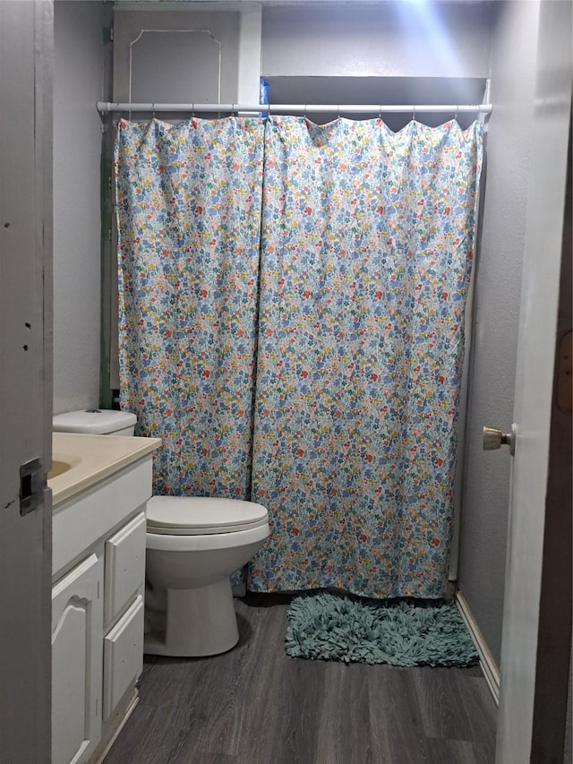 bathroom with hardwood / wood-style floors, vanity, toilet, and a shower with curtain